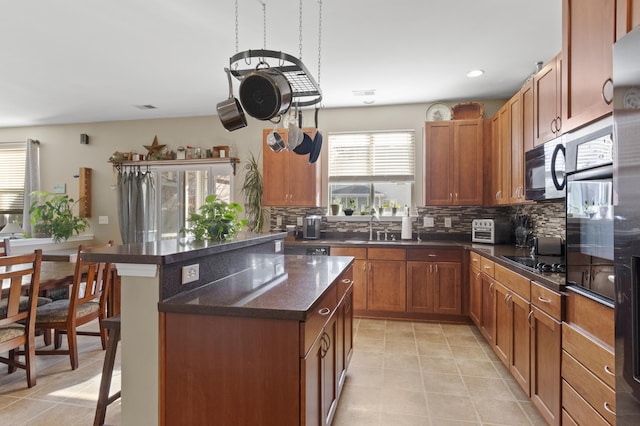 kitchen featuring a center island, decorative backsplash, a kitchen breakfast bar, and black appliances