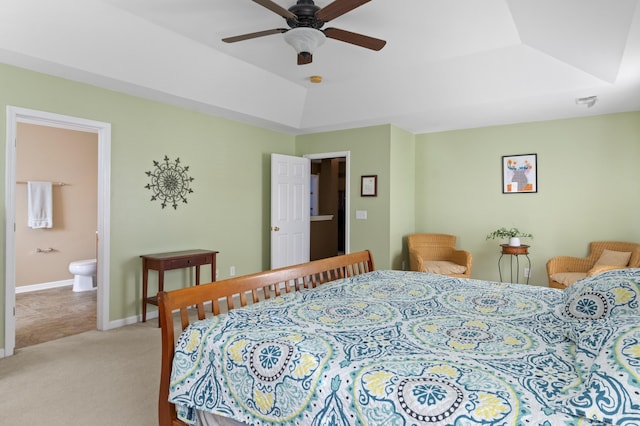 carpeted bedroom with a raised ceiling, ceiling fan, and ensuite bathroom