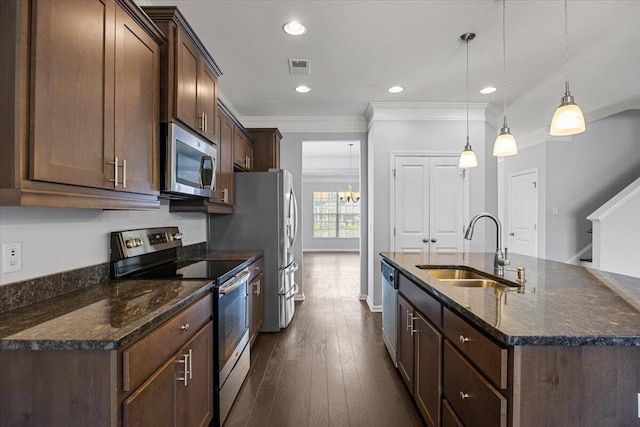 kitchen with decorative light fixtures, stainless steel appliances, dark stone counters, sink, and ornamental molding