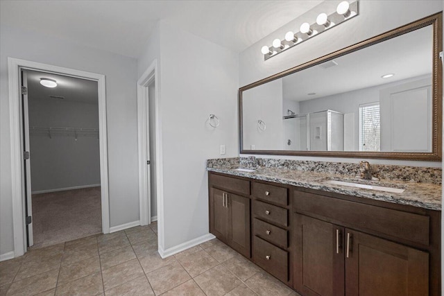 bathroom featuring a shower with shower door and vanity