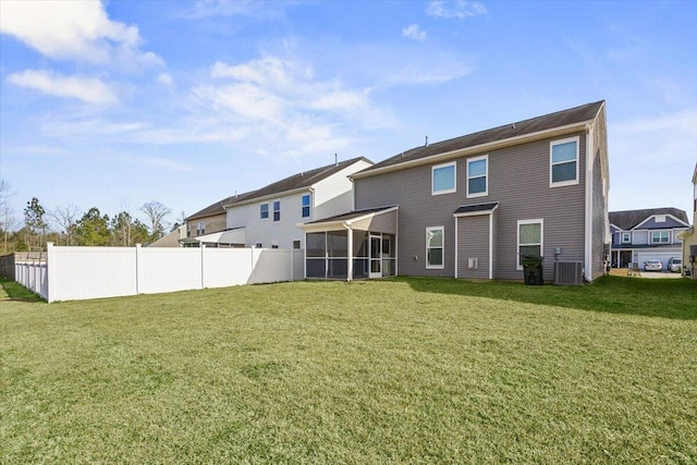 rear view of house with a yard and a sunroom