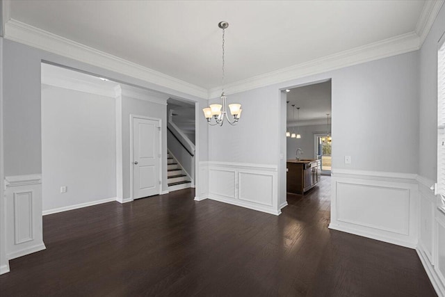 unfurnished dining area featuring dark wood-type flooring, ornamental molding, a chandelier, and sink