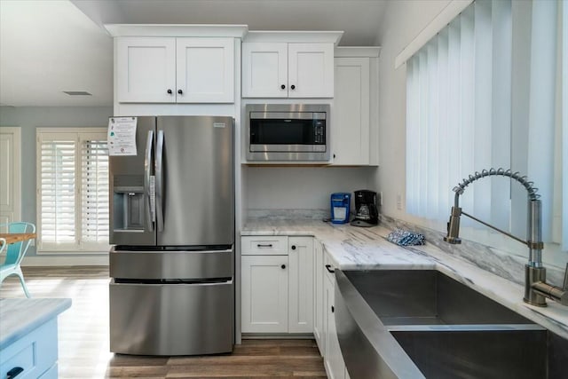 kitchen with white cabinets, appliances with stainless steel finishes, dark hardwood / wood-style flooring, and sink