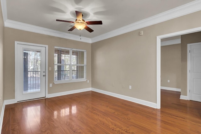 empty room featuring baseboards, ceiling fan, wood finished floors, and crown molding