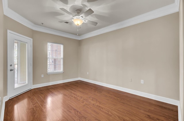 empty room with ornamental molding, dark wood finished floors, baseboards, and a ceiling fan