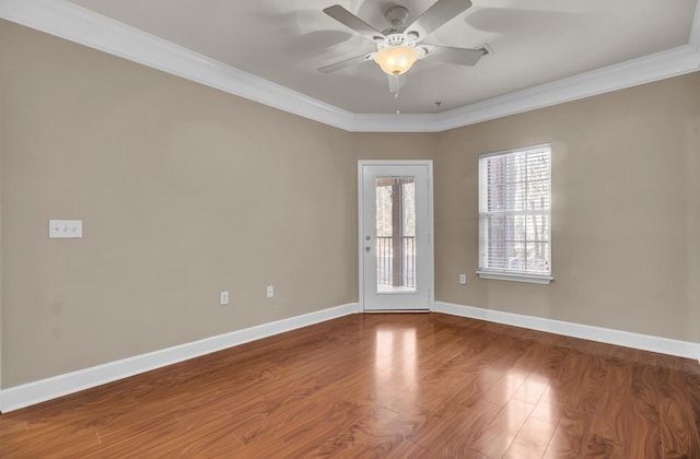 unfurnished room with ornamental molding, ceiling fan, baseboards, and wood finished floors