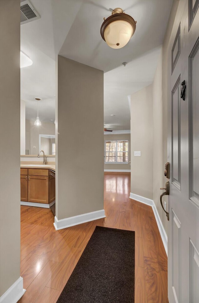 foyer featuring light wood-type flooring, visible vents, and baseboards