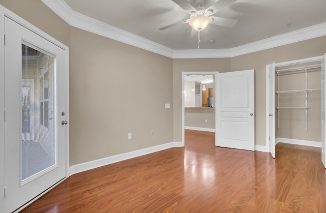 unfurnished bedroom with ornamental molding, a closet, wood finished floors, and baseboards