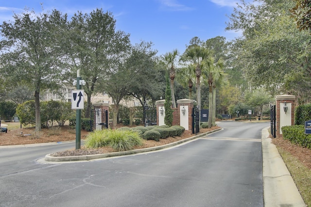 view of street featuring curbs, a gated entry, traffic signs, and a gate