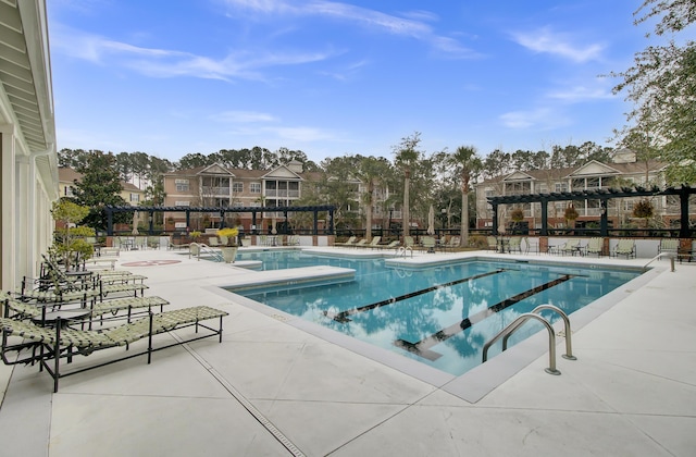 community pool with a patio and fence