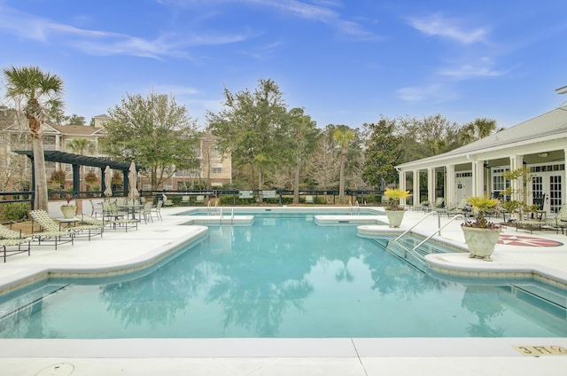 community pool featuring french doors, a patio area, fence, and a pergola