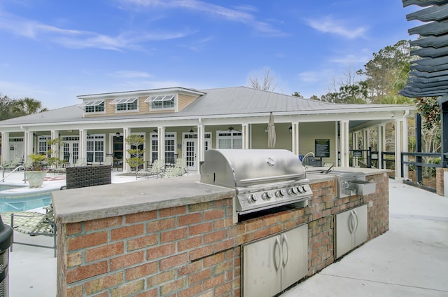 view of patio / terrace with an outdoor pool, a grill, an outdoor kitchen, and french doors