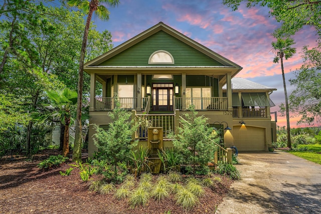 1520 Regimental Ln, Johns Island, SC 29455 - view of front of house with stucco siding, driveway, a porch, an attached garage, and a metal roof