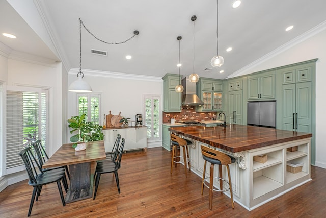 1520 Regimental Ln, Johns Island, SC 29455 - kitchen with green cabinetry, stainless steel appliances, a kitchen island with sink, dark wood-type flooring, and wall chimney exhaust hood