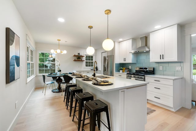886 Friendly Cir, Charleston, SC 29414 - kitchen with wall chimney exhaust hood, appliances with stainless steel finishes, light wood-style floors, a breakfast bar area, and a sink