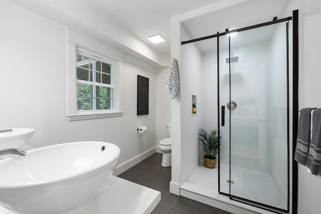 886 Friendly Cir, Charleston, SC 29414 - bathroom with toilet, a stall shower, a sink, baseboards, and wood finished floors
