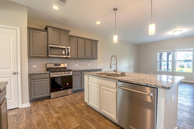 408 Fox Sparrow Ct, Summerville, SC 29486 - kitchen with stainless steel appliances, a sink, gray cabinetry, wood finished floors, and decorative backsplash