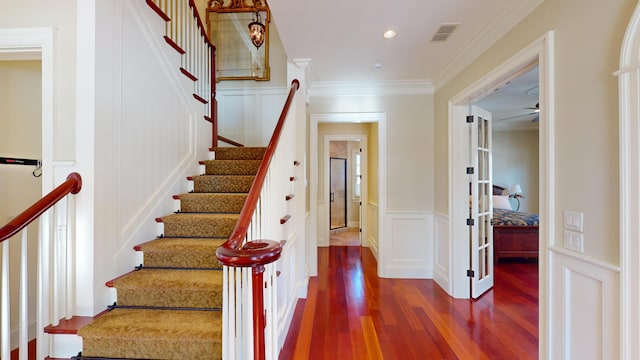 staircase featuring crown molding and hardwood / wood-style flooring