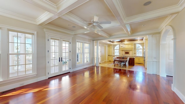 interior space with plenty of natural light, coffered ceiling, and light hardwood / wood-style flooring