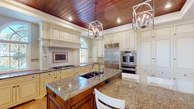 kitchen featuring stainless steel appliances, cream cabinets, wood ceiling, and decorative light fixtures