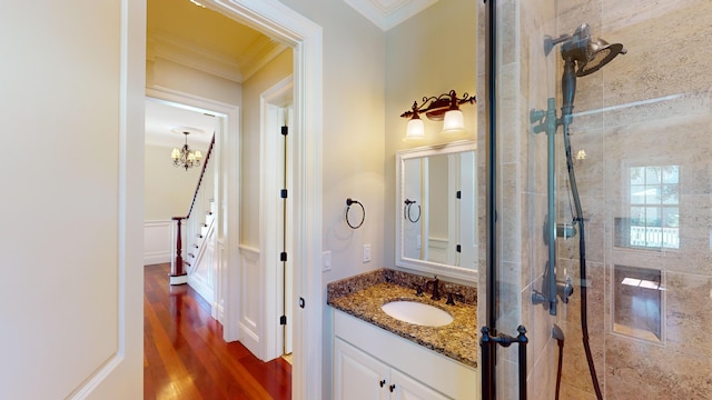 bathroom with vanity, crown molding, hardwood / wood-style flooring, and walk in shower