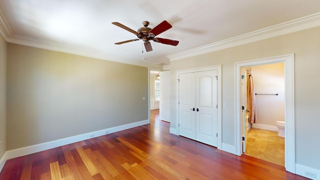 unfurnished bedroom with crown molding, dark wood-type flooring, ceiling fan, and a closet