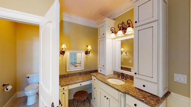 bathroom with ornamental molding, vanity, and toilet