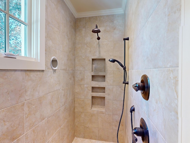 bathroom with ornamental molding and tiled shower