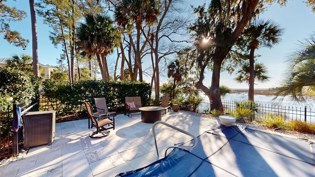 view of patio with a fire pit and a water view