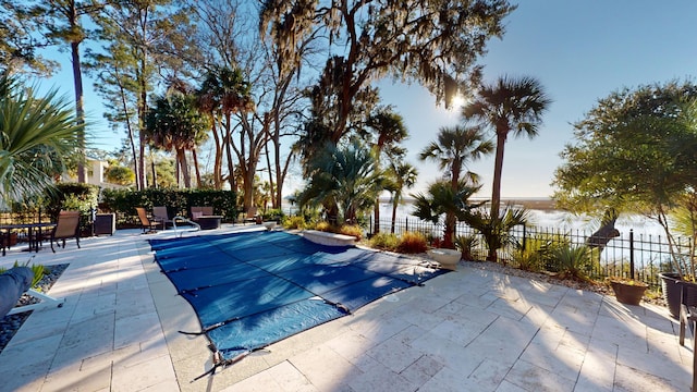 view of pool with a water view and a patio area