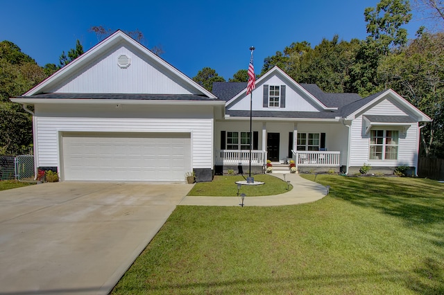 view of front of house featuring covered porch, a front yard, and a garage