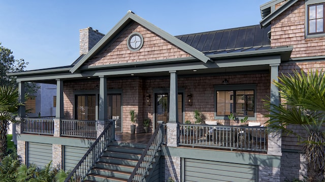 27 Rebellion Rd, Charleston, SC 29407 - view of front of house featuring a standing seam roof, covered porch, a chimney, metal roof, and an attached garage