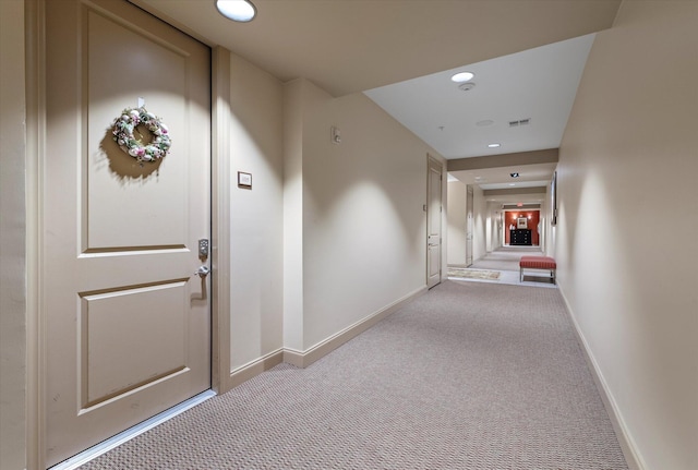 hall with light colored carpet