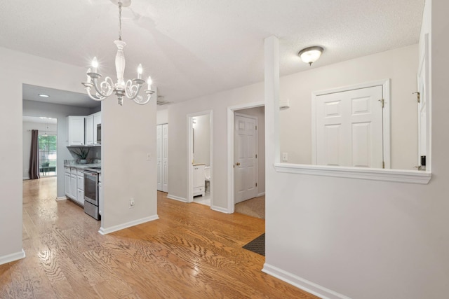 1505 Blaze Ln, Charleston, SC 29412 - kitchen featuring stainless steel electric range, a chandelier, light wood-style floors, and white cabinets