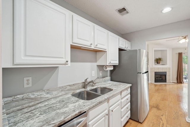 1505 Blaze Ln, Charleston, SC 29412 - kitchen with freestanding refrigerator, white cabinets, light wood-style flooring, light stone countertops, and ceiling fan