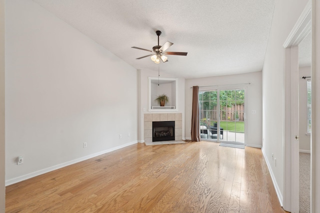 1505 Blaze Ln, Charleston, SC 29412 - unfurnished living room with light wood-style flooring, ceiling fan, a tile fireplace, and a textured ceiling