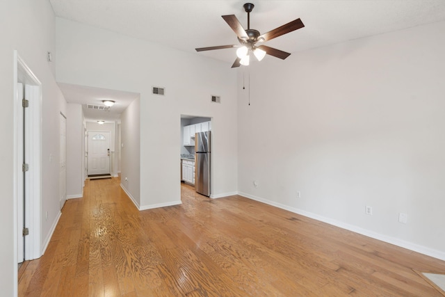 1505 Blaze Ln, Charleston, SC 29412 - unfurnished living room featuring a ceiling fan, light wood-style floors, and a towering ceiling