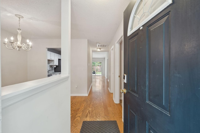 1505 Blaze Ln, Charleston, SC 29412 - entrance foyer with light wood-style floors, a chandelier, and a textured ceiling