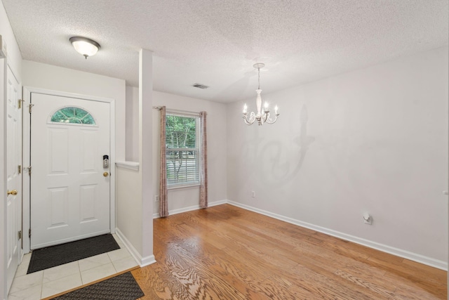 1505 Blaze Ln, Charleston, SC 29412 - entrance foyer with a chandelier, light wood-style flooring, and a textured ceiling