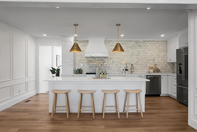5259 Hartford Cir N, Charleston, SC 29405 - kitchen with stainless steel appliances, custom range hood, a kitchen island, tasteful backsplash, and light countertops