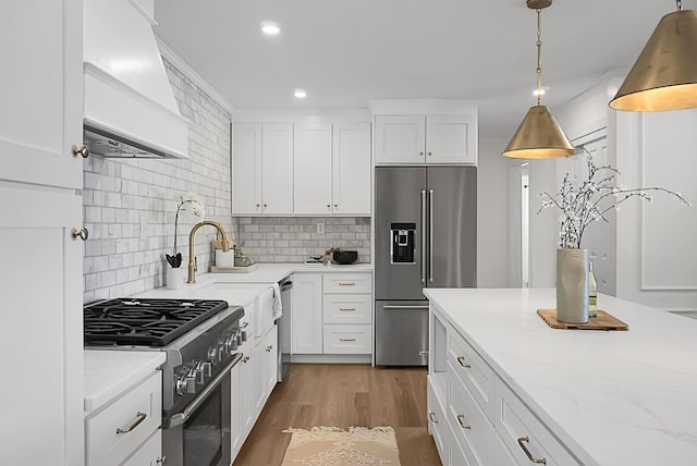 5259 Hartford Cir N, Charleston, SC 29405 - kitchen with high end appliances, custom range hood, tasteful backsplash, white cabinetry, and light stone countertops