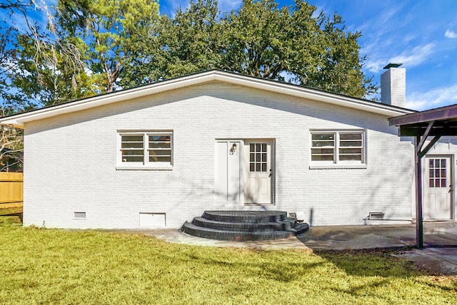 5259 Hartford Cir N, Charleston, SC 29405 - rear view of house featuring crawl space, brick siding, a yard, a patio area, and a chimney