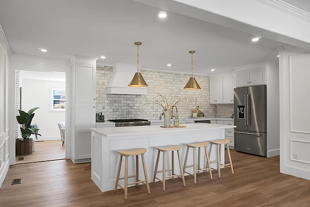 5259 Hartford Cir N, Charleston, SC 29405 - kitchen featuring high end refrigerator, premium range hood, a center island, backsplash, and light countertops