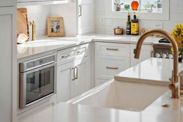 interior space with stainless steel oven and backsplash