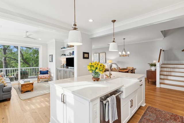 kitchen featuring dishwasher, a sink, light wood finished floors, open floor plan, and recessed lighting