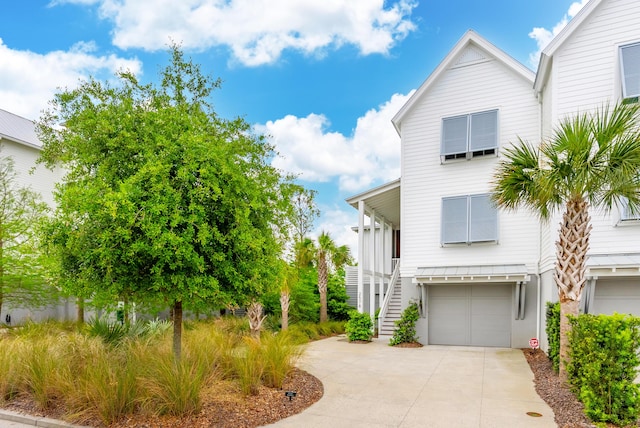view of front of property with stairway, an attached garage, and concrete driveway