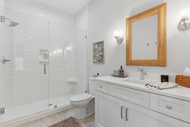 bathroom with vanity, toilet, and a shower stall