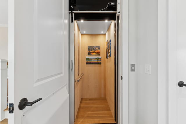interior space featuring recessed lighting, elevator, and wood finished floors