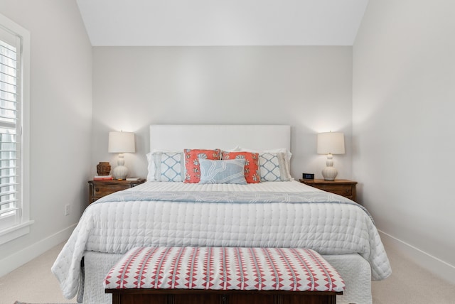 carpeted bedroom featuring baseboards and vaulted ceiling