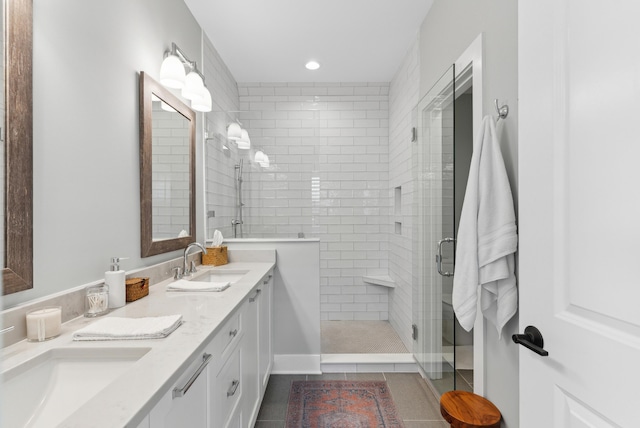 full bath with tile patterned flooring, a sink, a stall shower, and double vanity